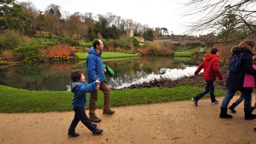 Visitors on a traditional winter trail through the parkland at Dyrham Park, Gloucestershire